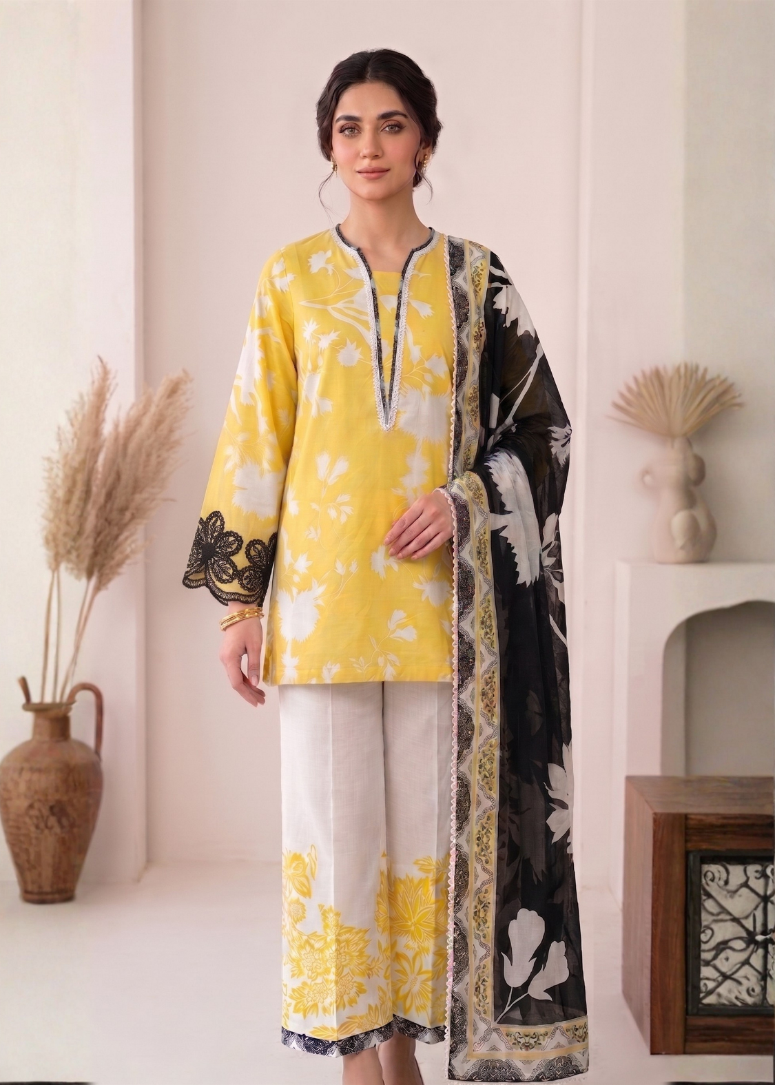 Woman wearing a yellow and black floral outfit with a matching scarf in a minimalistic setting.